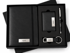 Four-piece brown corporate gift set with notebook, card holder, pen, and keychain